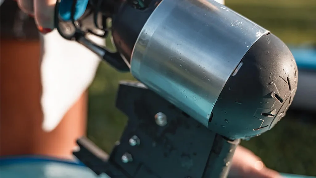 Person holding a Bixpy K-1 motor during kayak installation