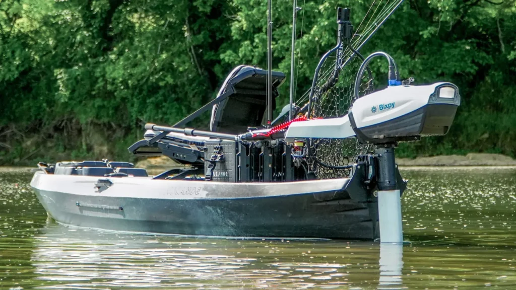 Bixpy N-3 outboard motor mounted on the stern of a fishing kayak in shallow water