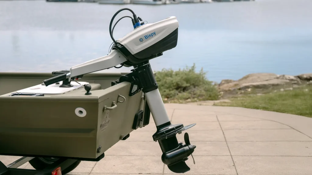 Bixpy N-3 outboard motor mounted on the stern of a small utility boat by the dock