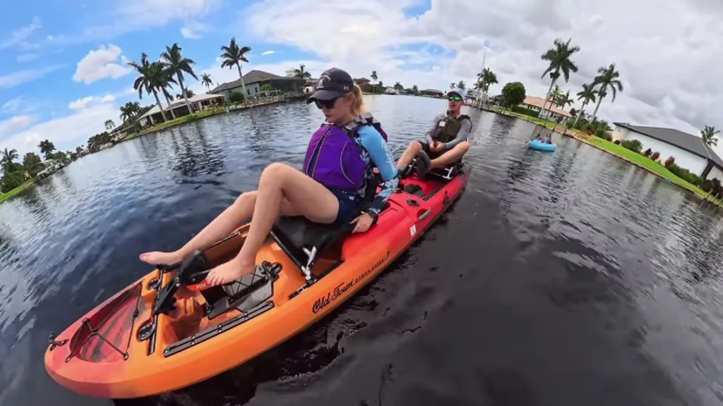 Two people pedaling the Old Town Malibu Pedal T tandem kayak during an on-water test in a Florida canal.