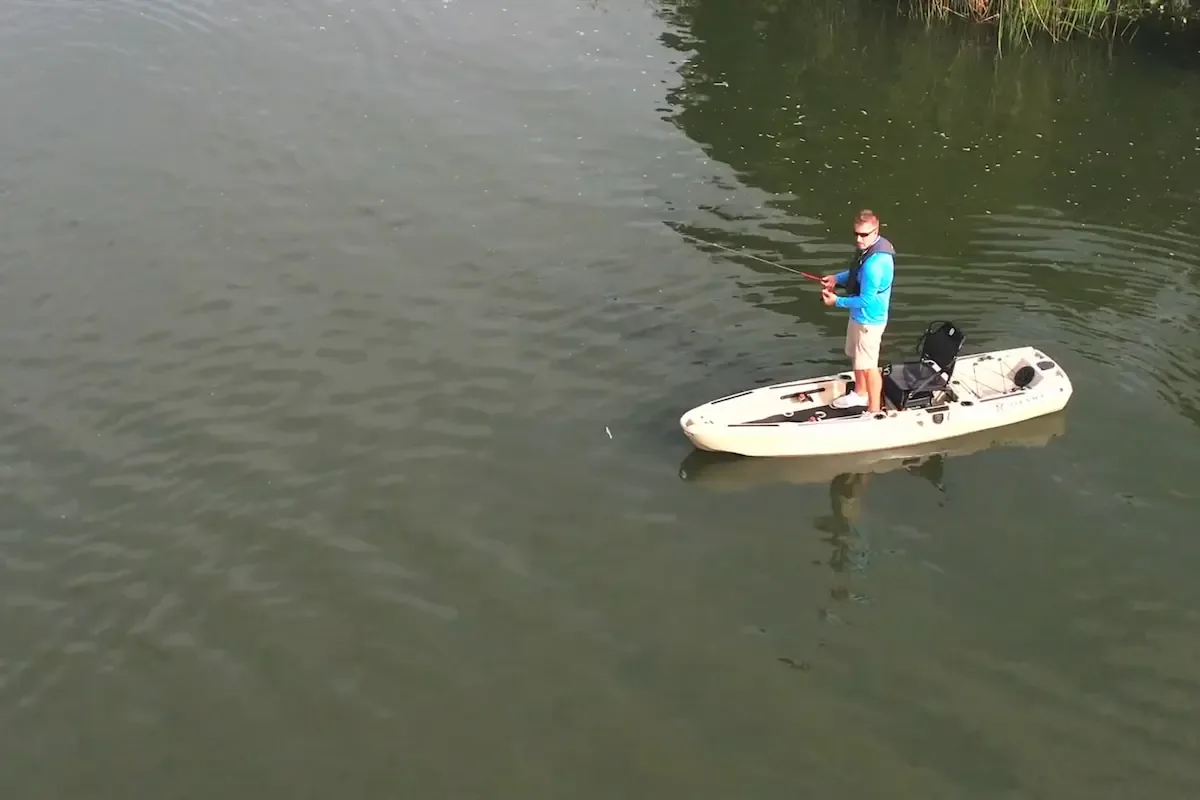 Angler standing on a FluxJet electric fishing kayak during an on-water test