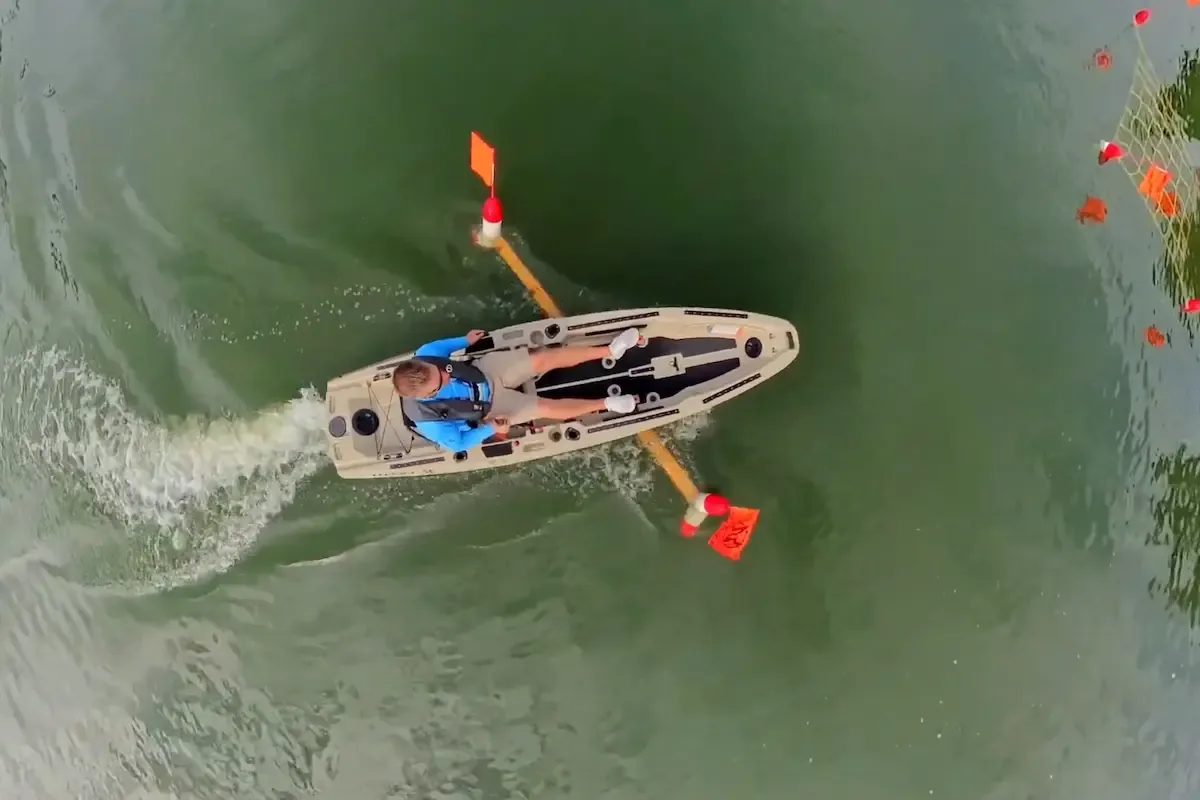 Overhead view of the FluxJet kayak using foot steering near aquatic weeds