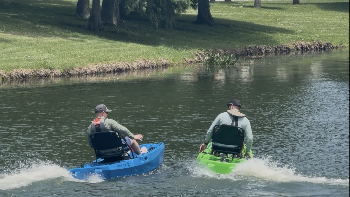 Blue and green FluxJet kayaks racing on open water