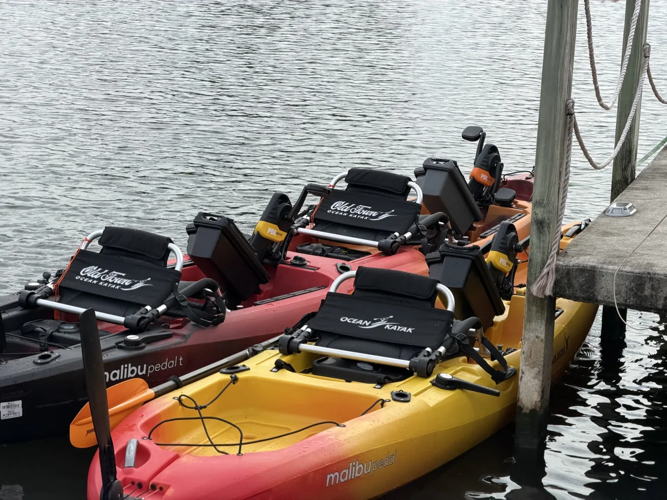 Three Old Town Malibu PDL pedal kayaks lined up at the dock